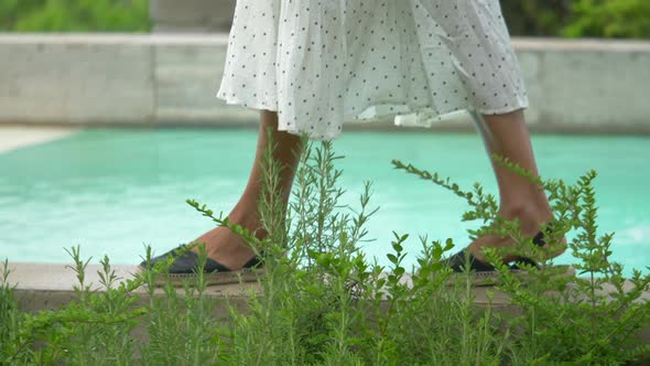 Closeup of woman walking in dress, feet and sandals traveling at a luxury resort in Italy, Europe.