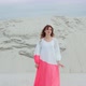 Model Woman in Dress Walking on the Sand Smiling at Camera Stones in the Background - VideoHive Item for Sale