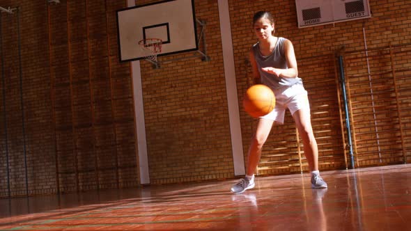 Determined schoolgirl practicing basketball 4k