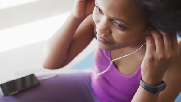 Happy african american wearing sportswear and earphones, exercising