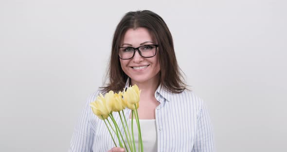 Happy Middle-aged Woman with Bouquet of Tulips on White Background