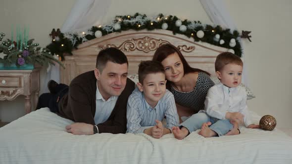 Happy Young Family Lying on the Bed