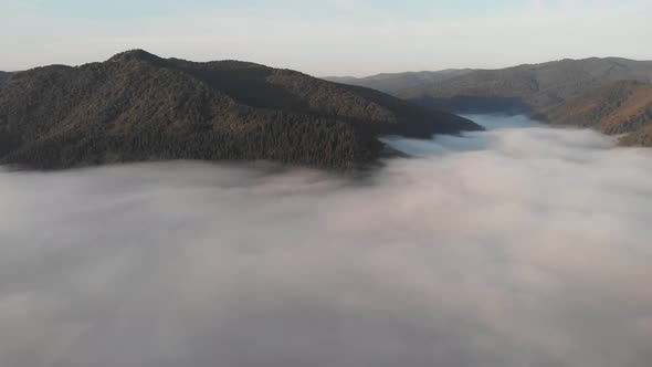 Aerial View Flight Over Clouds Between Mountains