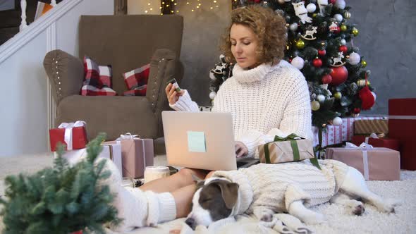Christmas Online Shopping Concept. Female Buyer Makes Order On Laptop At Home