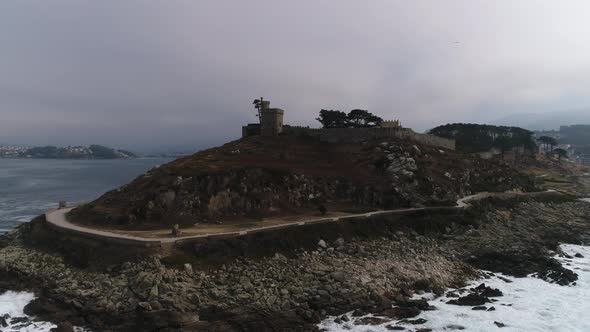 Drone flight above the waves clashing on the rocks in Baiona, Galicia, Spain