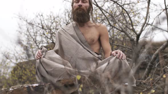 Ascetic Yogi Meditating in Mountains