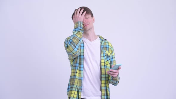 Stressed Young Man Using Phone and Getting Bad News