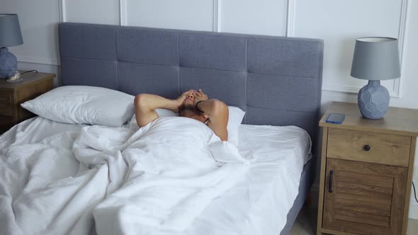 Man Waking Up in the Morning Standing Up From Bed in Bedroom