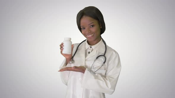 Smiling African American Female Doctor with Stethoscope Advertising Medicine on Gradient Background.