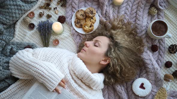 Winter Holiday Concept. Girl In Knitted Sweater Resting On Bed