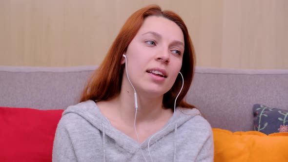 Calm Happy Young Woman in Headphones Chilling Sitting on Sofa