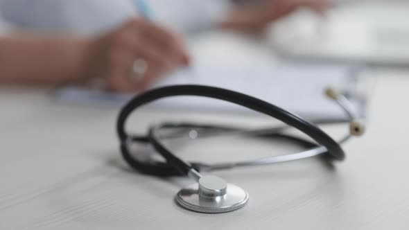 Close up of Stethoscope Medical Equipment With Female Doctor Working in Background