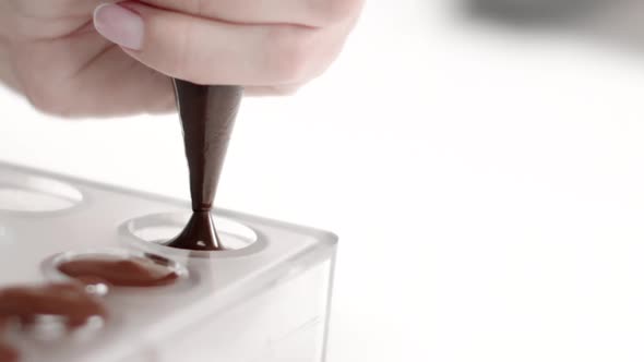 Chocolatier Pouring Melted Chocolate Into Candy Mold for Handmade Candy Slow Mo