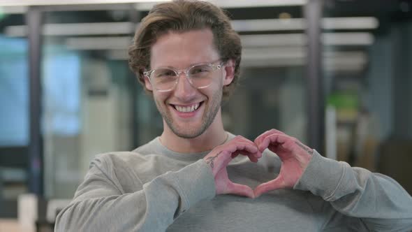 Portrait of Young Businessman Showing Heart Sign By Hand