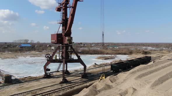 Loading Sand Into Rail Cars with the Help of a Career Excavator