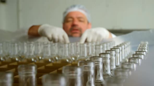 Male worker holding bottles in factory 4k