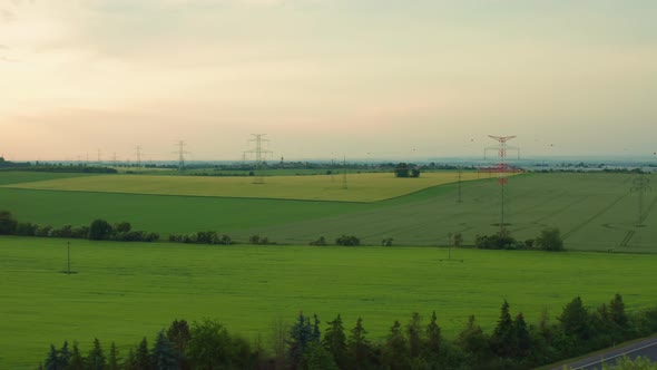 Power Transmission Lines in Field at Sunset Aerial View