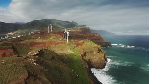 Renewable Wind Energy Station on the Edge of a Cliff Washed with the Ocean