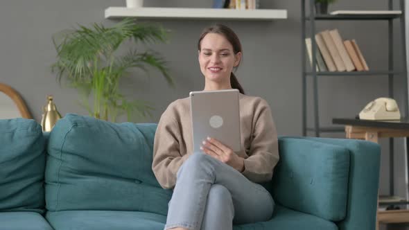 Woman Talking on Video Call on Tablet on Sofa