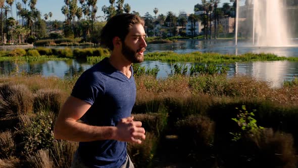 Athletic Man Jogging Around A Small Lake