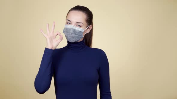 Woman in Protective Mask Shows Thumb Up, Peace Gesture, Great Sign, Isolated