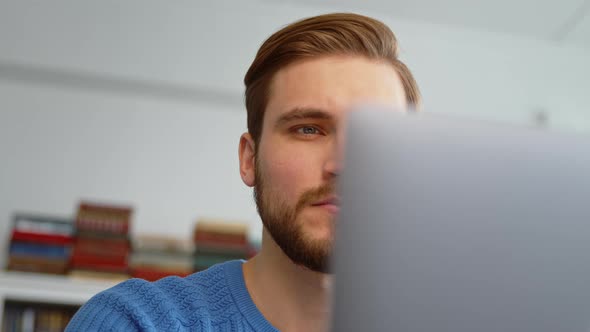 Thoughtful businessman thinking about online project while looking at laptop