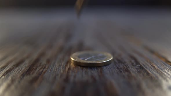 Some euro coins falling down on wooden background. Closeup view and soft focus, slow motion