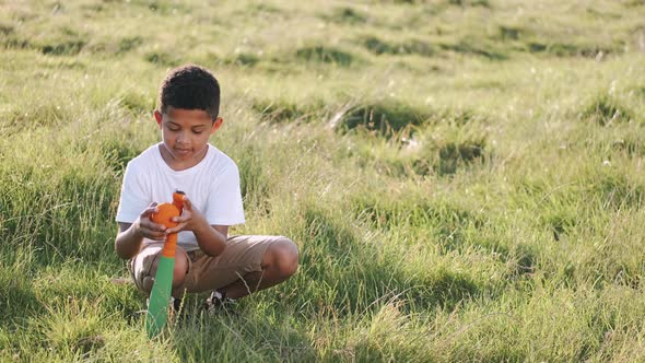 African Boy Playing Baseball in the Field on Sunset