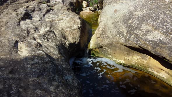 Water erodes a course through the granite rocks at Giant's Cauldron near Alicante, Spain - following