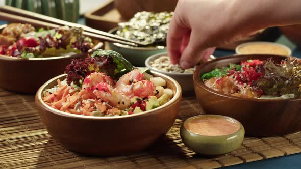 Sprinkling Sesame Seeds on Cooked Poke Bowl Closeup