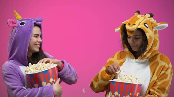 Female Friends in Funny Pajamas Having Fun Throwing Popcorn to Each Other