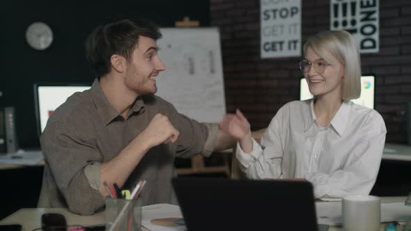 Business Couple Giving Five in Dark Office. Excited Team Celebrating Success.