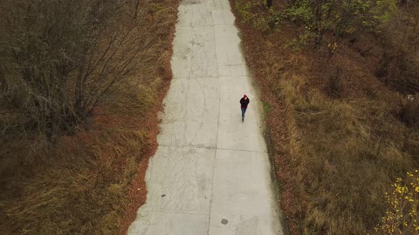 Aerial View of Woman Going on Destroyed Road Alone in Countryside