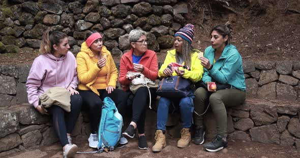 Multiracial women taking a break in the forest during hiking day