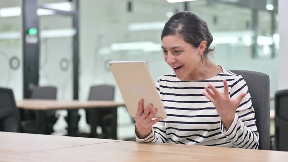 Excited Indian Woman Celebrating Success on Digital Tablet in Office 