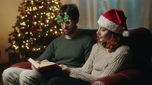 Couple read a book and smile together on Christmas mood