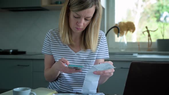 Woman Calculating Payment Bill in Kitchen