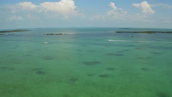 Aerial of boats traveling past islands in the florida keys
