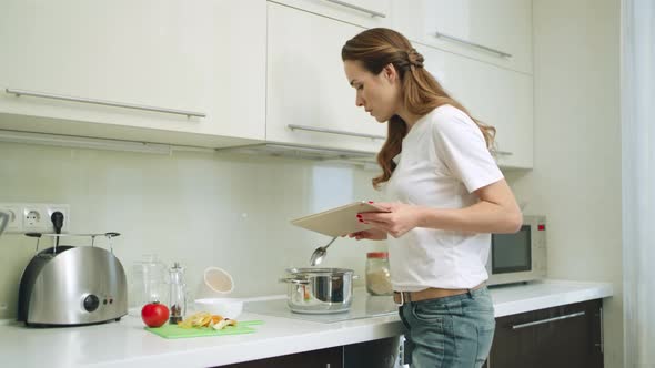 Young Woman Cooking Meal at Home Kitchen.