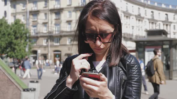 Woman Searching Information on a Smart Phone on the City Street. Technology and Lifestyle Concept