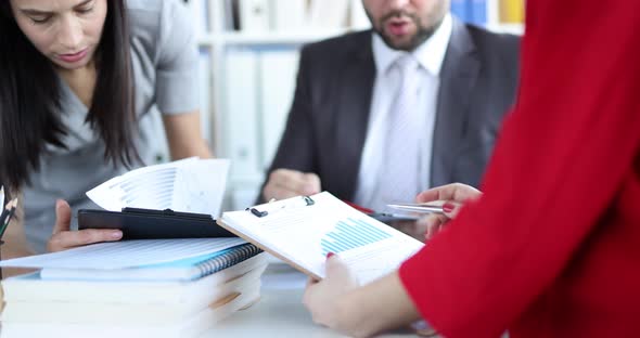 Puzzled People in the Office Look at Documents with Charts