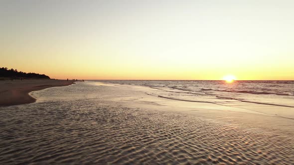 Aerial Low Flight: People Enjoy Scenic Sunset on Baltic Sea