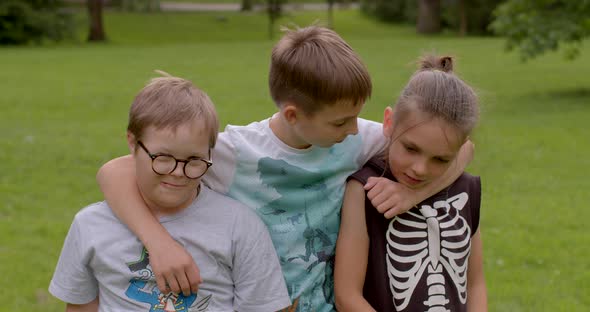 Portrait of Children Pose Looking Hugging in City Park Boy with Down Syndrome