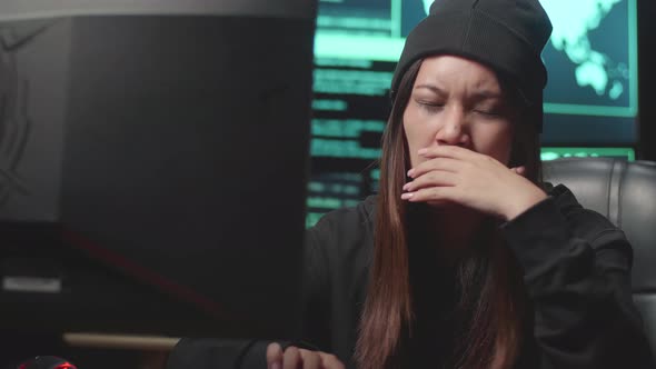 Young Asian Woman Hacker Yawn And Sleep On Computer Table, Code On Multiple Computer Screens