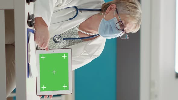 Vertical Video Physician Holding Horizontal Greenscreen on Digital Tablet