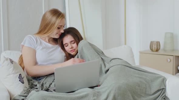 Adult Mother with Teenager Daughter Sitting on Couch Using Laptop Online Browsing Network Watching