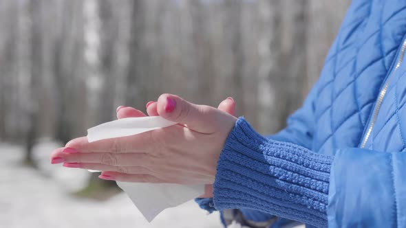 The Girl Wipes Her Hands with a Antibacterial Wipe on the Street. Prevention and Protection of