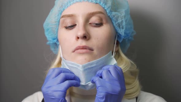 Dramatic Video Portrait of an Exhausted Nurse Taking Off the Protection Surgical Face Mask in the