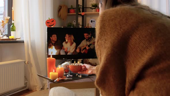 Woman Watches Tv and Drinks Cocoa on Halloween