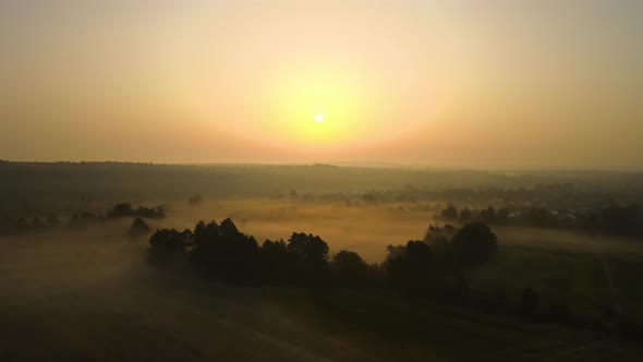 Aerial Landscape View of Sunny Morning Over Foggy Green Fields